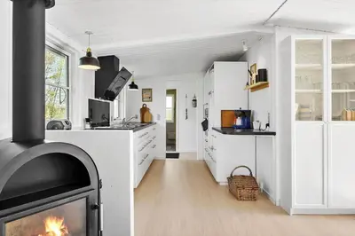 a living room with a fireplace in a kitchen at JB323-Fjerritslev-Markstien-21 in Fjerritslev