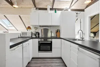 a kitchen with white cabinets and black counter tops at JB578-Fjerritslev-Hasselvej-57 in Fjerritslev