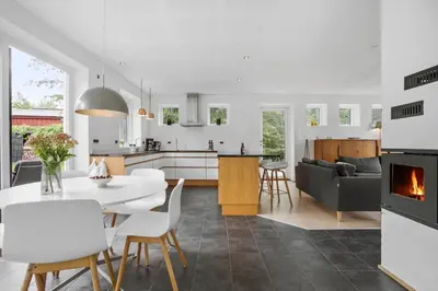 a kitchen and living room with a table and a fireplace at JB1031-Fjerritslev-Thorup-Strandvej-266 in Fjerritslev