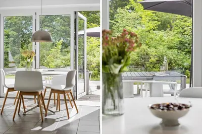 a kitchen and dining room with a table and a vase of flowers at JB1031-Fjerritslev-Thorup-Strandvej-266 in Fjerritslev