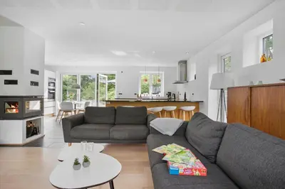 a living room with a gray couch and a kitchen at JB1031-Fjerritslev-Thorup-Strandvej-266 in Fjerritslev