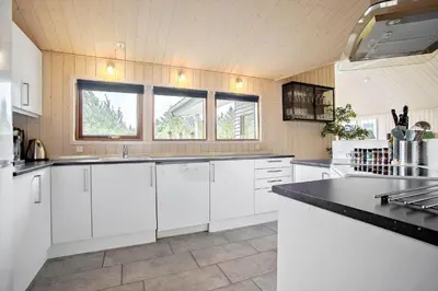 a kitchen with white cabinets and a black counter top at JB193-Fjerritslev-Blabaerstien-78 in Fjerritslev