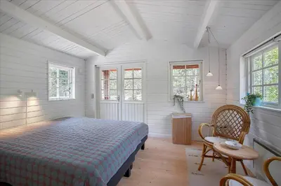 a bedroom with a bed and a table and windows at JB160-Fjerritslev-Skovstien-7 in Fjerritslev