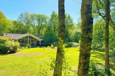 a house in the middle of a yard with trees at JB901-Aabybro-Graanden-40 in Åbybro