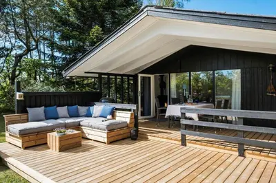 a wooden deck with a couch and a table at JB922-Fjerritslev-Birkevej-25 in Fjerritslev