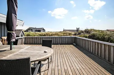 a wooden deck with a table and chairs on it at JB340-Frostrup-Krinkelkrogen-14 in Frøstrup