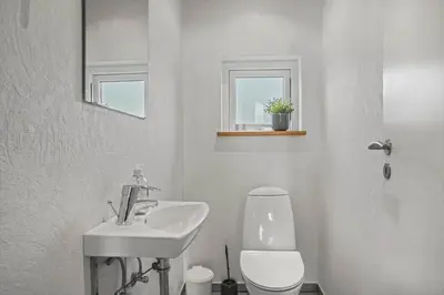 a white bathroom with a sink and a toilet at JB225-Brovst-Kronvildtvej-218 in Brovst