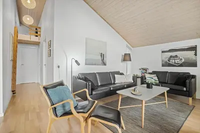 a living room with a couch and a table and chairs at JB225-Brovst-Kronvildtvej-218 in Brovst