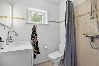 a bathroom with a toilet and a sink and a window at JB151-Brovst-Tranum-Engevej-137 in Brovst
