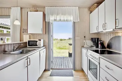 a kitchen with white cabinets and a door to a yard at JB785-Fjerritslev-Tolderstien-24 in Fjerritslev