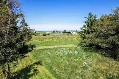a field with trees and the ocean in the background at JB785-Fjerritslev-Tolderstien-24 in Fjerritslev