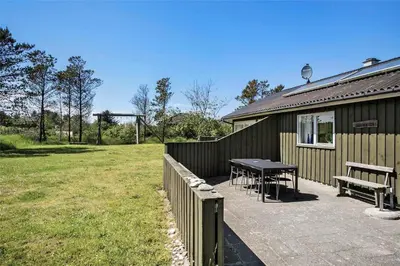 a patio with a table and benches next to a building at JB785-Fjerritslev-Tolderstien-24 in Fjerritslev