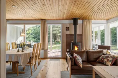 a living room with a table and a couch and a fireplace at JB157-Brovst-Krogen-24 in Brovst