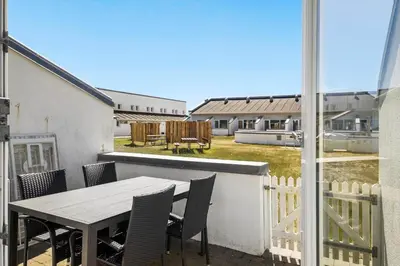 a table and chairs on a balcony with a view of a yard at JB889-Brovst-Strandvejen-150-Lejl-130 in Brovst