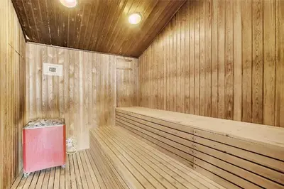 a wooden sauna with a red trash can in it at JB889-Brovst-Strandvejen-150-Lejl-130 in Brovst