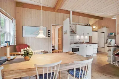 a kitchen with a large wooden table and chairs at JB136-Brovst-Harestien-1 in Brovst