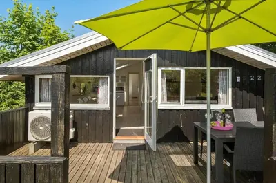 a large yellow umbrella on a deck with a house at JB236-Fjerritslev-Ahornvej-22 in Fjerritslev
