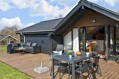 a wooden deck with a black table and chairs at JB229-Fjerritslev-Hasselvej-13 in Fjerritslev