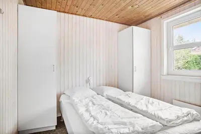 a bedroom with a white bed and a window at JB305-Fjerritslev-Tyttebaerstien-18 in Fjerritslev