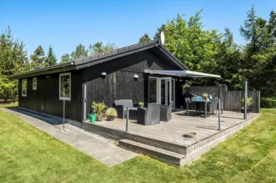 a black tiny house with a wooden deck at JB128-Fjerritslev-Pilevej-2 in Fjerritslev
