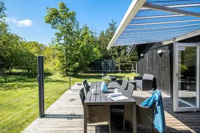 a patio with a table and chairs on a deck at JB128-Fjerritslev-Pilevej-2 in Fjerritslev