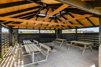 a group of benches sitting under a pavilion at JB215-Brovst-Kronvildtvej-194 in Brovst