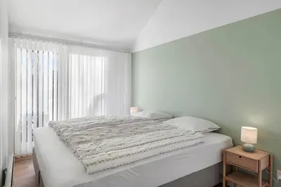 a white bedroom with a large bed and a window at JB215-Brovst-Kronvildtvej-194 in Brovst