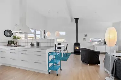 a white kitchen with a blue chair in a room at JB140-Frostrup-Svenstibakkevej-68 in Frøstrup