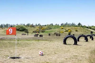 a soccer ball sitting in a field with tires at JB214-Brovst-Kronvildtvej-214 in Brovst