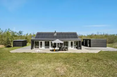a black house with a solar roof on a field at JB214-Brovst-Kronvildtvej-214 in Brovst