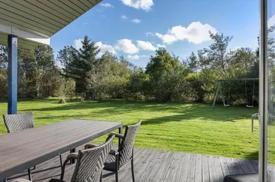 a wooden deck with a picnic table and chairs at JB219-Fjerritslev-Tyttebaerstien-4 in Fjerritslev
