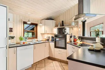 a kitchen with white cabinets and black counter tops at JB245-Fjerritslev-Tyttebaerstien-44 in Fjerritslev