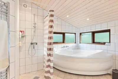 a white bathroom with a tub and a shower at JB245-Fjerritslev-Tyttebaerstien-44 in Fjerritslev