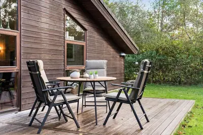 a patio with a table and chairs on a deck at JB245-Fjerritslev-Tyttebaerstien-44 in Fjerritslev
