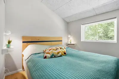 a bedroom with a bed with a wooden headboard and a window at JB294-Fjerritslev-Perikumvej-72 in Fjerritslev