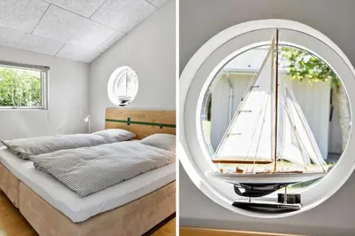 a bedroom with a bed and a mirror with a sailboat on it at JB294-Fjerritslev-Perikumvej-72 in Fjerritslev