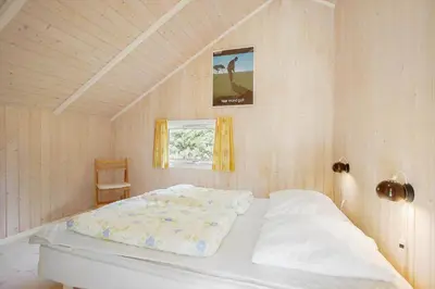 a bedroom with a bed and a chair in it at JB329-Brovst-Egernvej-29 in Brovst