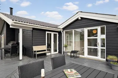 a patio with a table and chairs on a deck at JB234-Frostrup-Strandvejen-83-A in Frøstrup