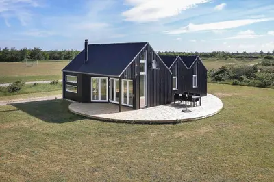 a small black house on a grass field at JB176-Brovst-Kronvildtvej-152 in Brovst