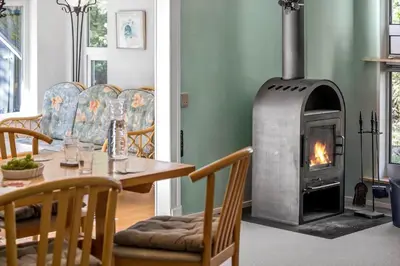 a dining room with a table and a wood stove at JB246-Brovst-Graevlingevej-13 in Brovst