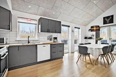 a kitchen with a table and some chairs and a kitchen with a tableablish at JB876-Brovst-Kronvildtvej-40 in Brovst