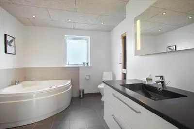 a bathroom with a tub and a sink and a bath tub at JB876-Brovst-Kronvildtvej-40 in Brovst