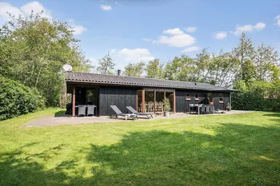 a house with a patio and a grass yard at JB126-Fjerritslev-Tyttebaerstien-48 in Fjerritslev