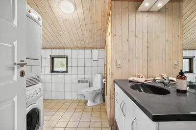 a bathroom with a sink and a washer and dryer at JB126-Fjerritslev-Tyttebaerstien-48 in Fjerritslev