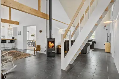 a living room with a fireplace and a staircase at JB175-23-Brovst-Kronvildtvej-60 in Brovst