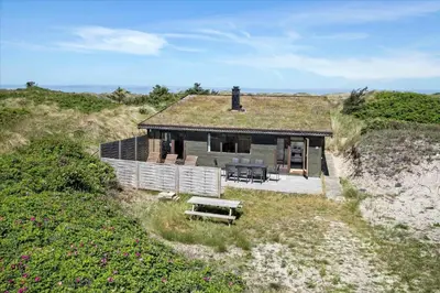 a small house with a grass roof on a beach at JB171-Brovst-Ejstrup-Strandvej-28 in Brovst