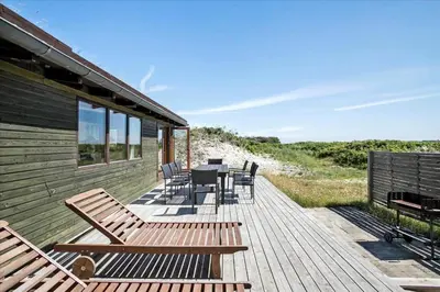 a wooden deck with a table and chairs on a house at JB171-Brovst-Ejstrup-Strandvej-28 in Brovst