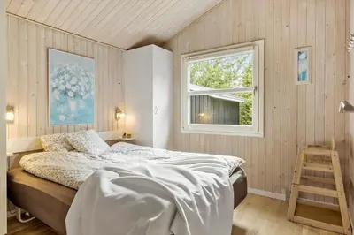 a bedroom with a bed and a window and a ladder at JB716-Fjerritslev-Tyttebaerstien-16 in Fjerritslev