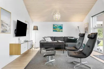 a living room with a couch and a table and chairs at JB239-Brovst-Kronvildtvej-208 in Brovst