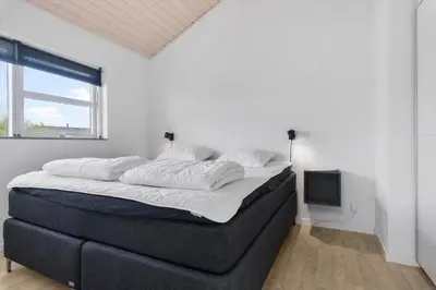 a large bed in a white room with a window at JB239-Brovst-Kronvildtvej-208 in Brovst